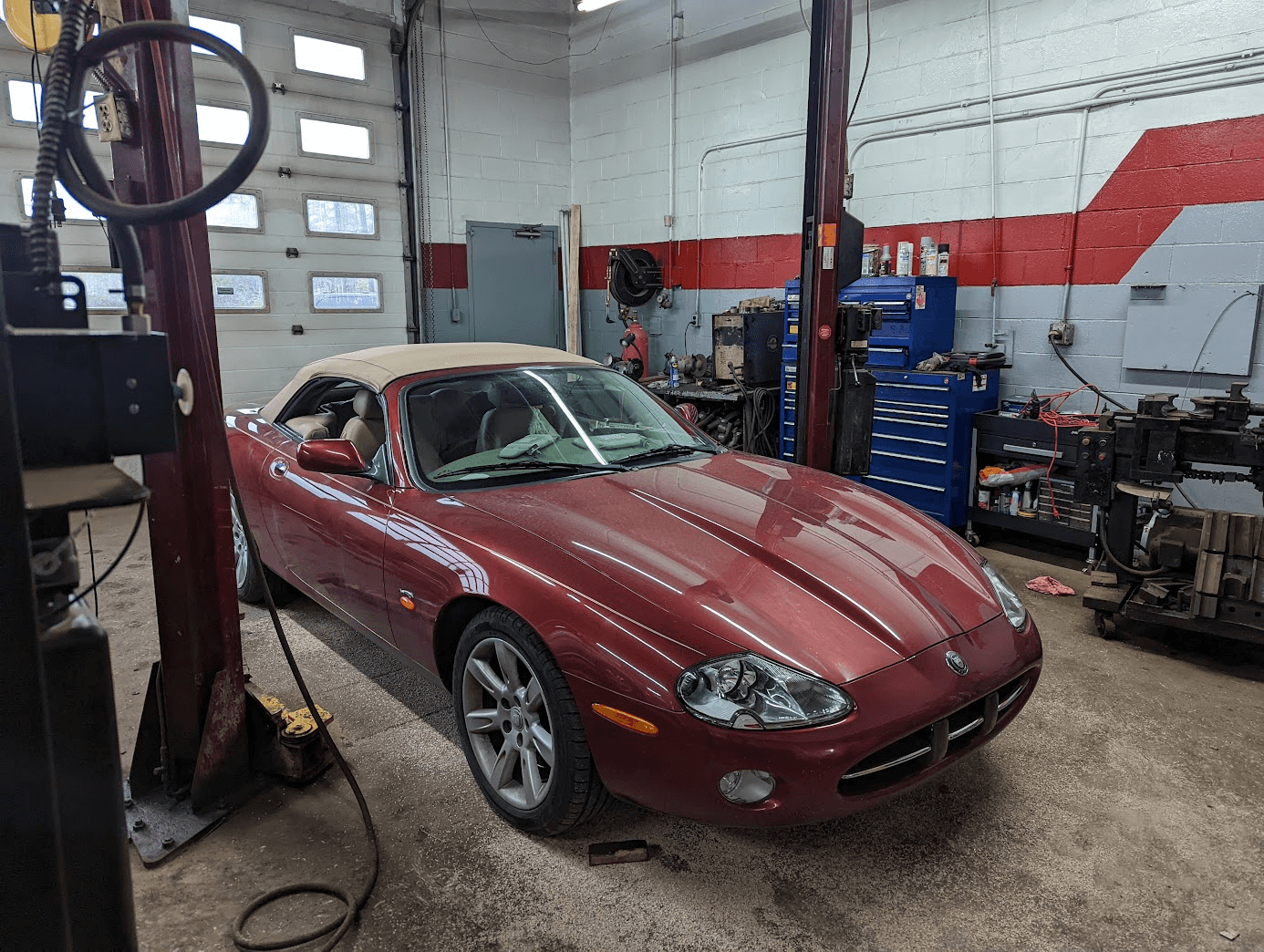 A red Jaguar XK convertible between the lifts.